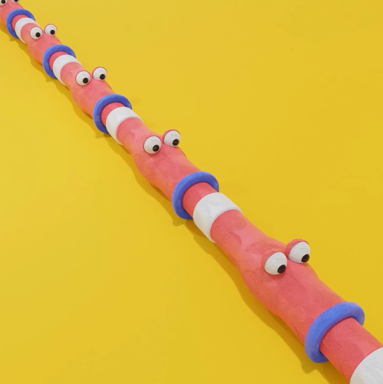 A row of worms eating each other in claymation style